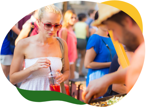 A blonde woman in summer white top and sunglasses at a food stall