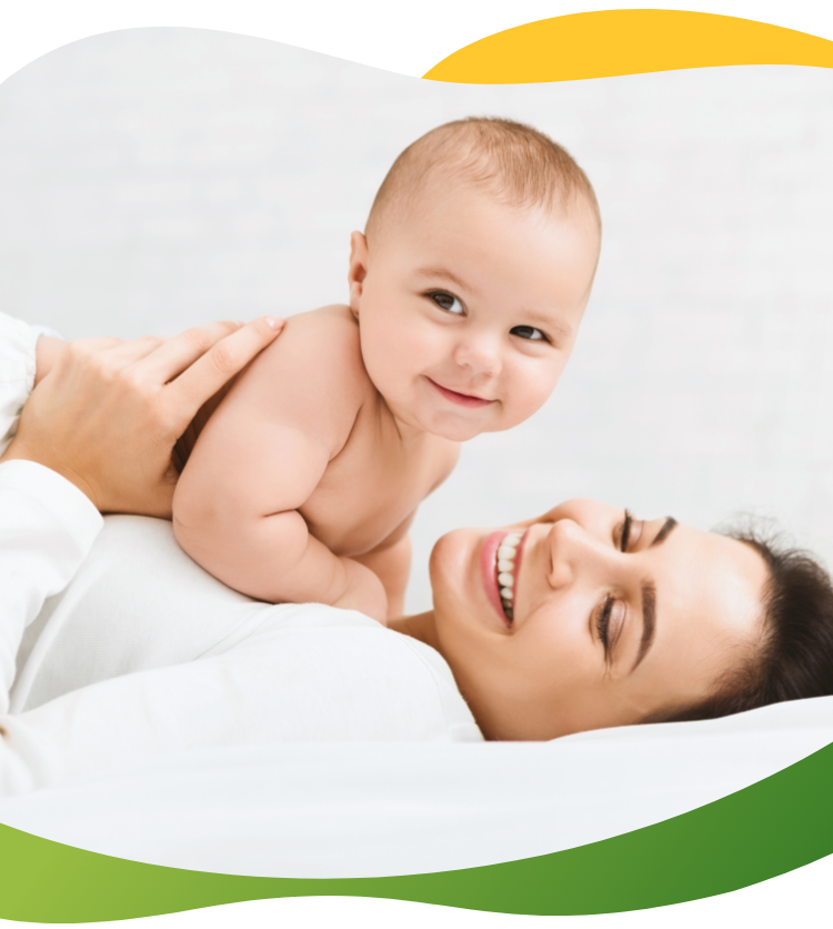 A happy baby lying on his smiling mother is looking curiously at the camera